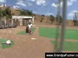 Chick fucks senior at a baseball court